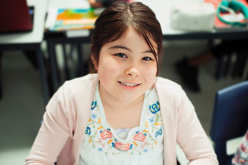 elementary aged student working on a laptop