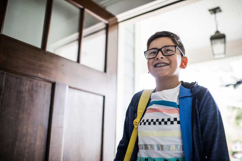 young boy entering a home