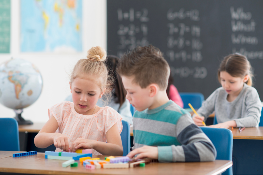 Photo of a teenage girl smiling into the camera, holding a tablet computer.